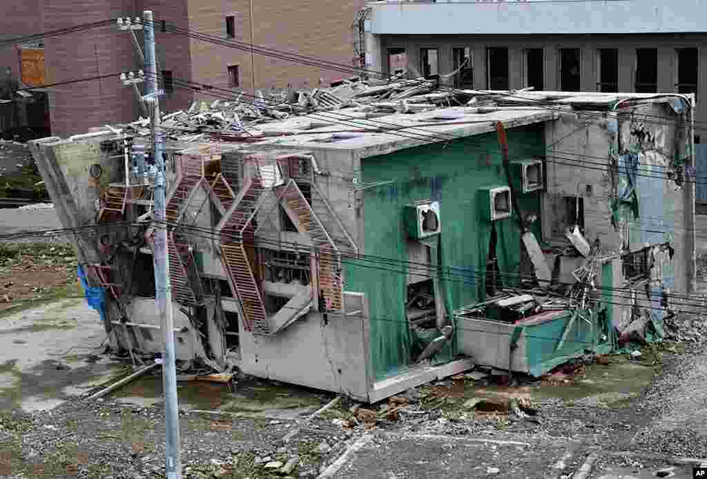 A building toppled by the tsunami still on its side in Onnagawa, March 9, 2012. (VOA - S. L. Herman)