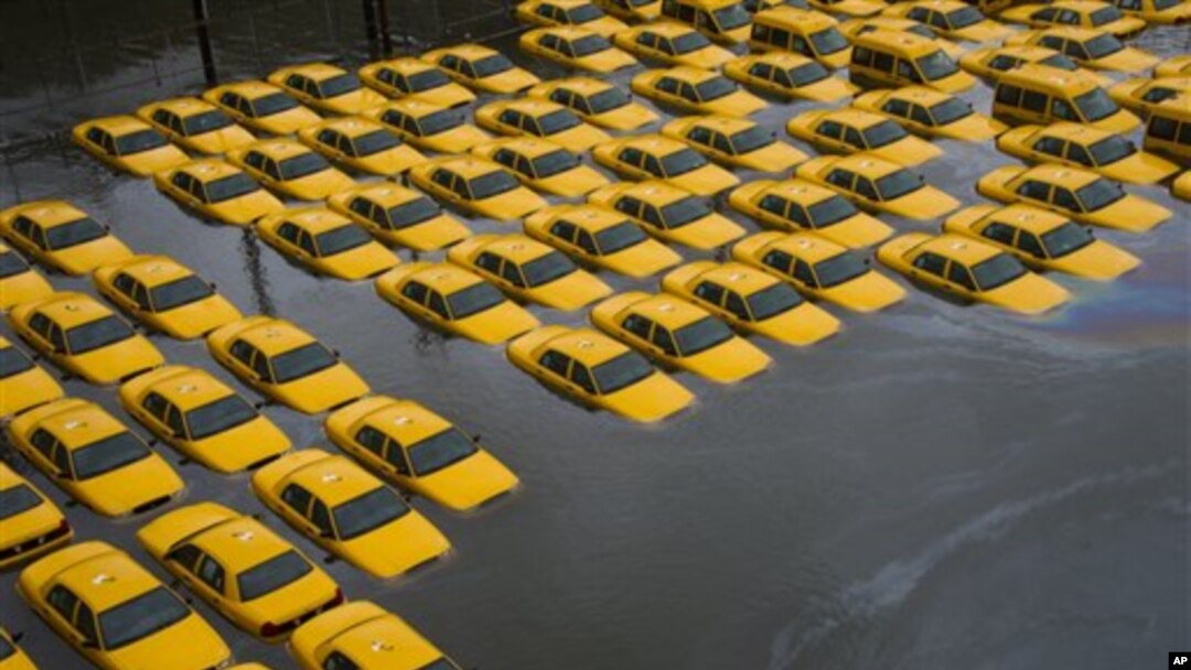 Taksi-taksi terendam oleh luapan air banjir akibat badai Sandy di lapangan parkir di Hoboken, New Jersey (30/10).