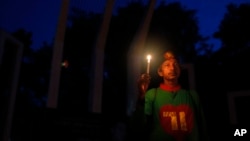 FILE - A Bangladeshi activist holds a candle, as they protest against the killing of secular blogger Niladri Chottopadhay Niloy in Dhaka, Bangladesh, Friday, Aug. 14, 2015.