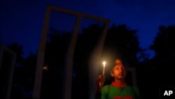 A Bangladeshi activist holds a candle, as they protest against the killing of secular blogger Niladri Chottopadhay Niloy in Dhaka, Bangladesh, Friday, Aug. 14, 2015.