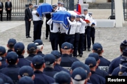 The flag-draped coffins of French police commander Jean-Baptiste Salvaing and his companion, administrative agent Jessica Schneider, are carried during a ceremony, in Versailles, near Paris, France, June 17, 2016.