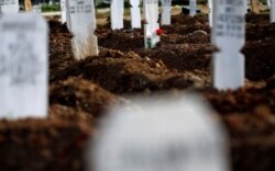 Bunga diletakkan di atas kuburan di areal pemakaman umat Islam yang disediakan pemerintah untuk korban Covid-19 di kompleks pemakaman Tegal Alur, Jakarta, 1 Desember 2020. (Foto: Reuters/Willy Kurniawan)