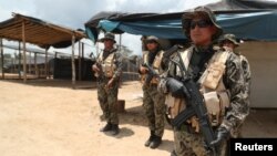 Peruvian military guard an illegal gold mining camp during a operation to destroy illegal machinery and equipment used by wildcat miners in Madre de Dios, Peru, March 5, 2019. 