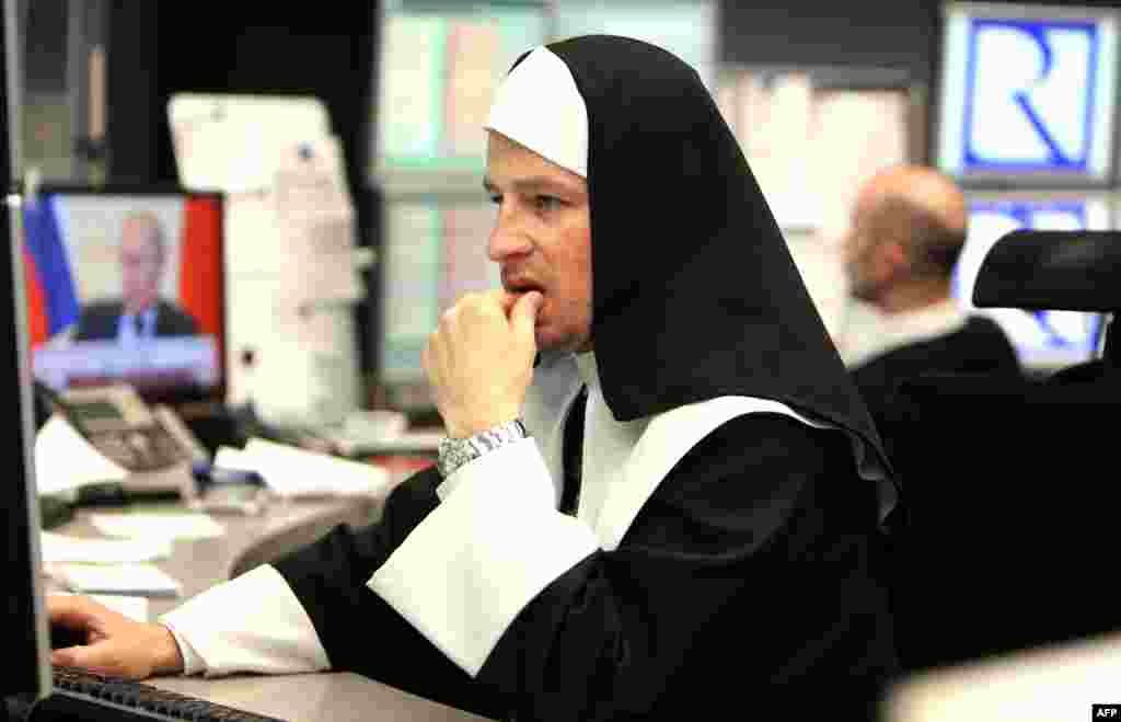 A stock trader dressed up as nun works at the traditional stock exchange carnival in Frankfurt, Germany.