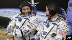 El astronauta estadounidense Nick Hague (derecha) y el cosmonauta ruso Alexey Ovchinin hablan antes de despegar a bordo de una cápsula Soyuz MS-10 hacia la Estación Espacial Internacional, en Baikonur, Kazajistán, el 11 de octubre de 2018. (AP Foto/Dmitri Lovetsky) 