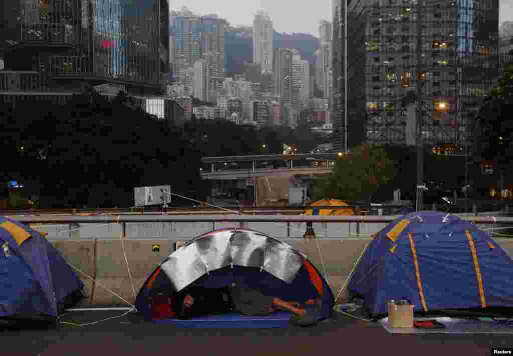Seorang demonstran pro-demokrasi tidur di sebuah tenda, di sebuah jembatan pusat distrik keuangan Hong Kong&nbsp;yang mereka kuasai, 6 November 2014. 