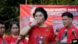 FILE - Former Philippine First Lady Imelda Marcos blows kisses to supporters. The Philippine government will launch a website to crowd-source tips on the whereabouts of some 200 missing art works formerly owned by Marcos.