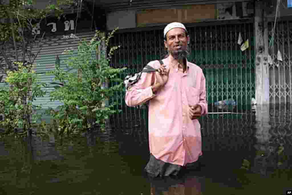 A Pakistani migrant worker trudges through floodwater to see if his mosque is still open, Bangkok, Thailand, October 28, 2011. (VOA)