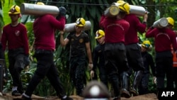 Tentara Thailand membawa tangki-tangki oksigen dalam operasi penyelamatan 12 remaja pria dan pelatih tim sepak bola mereka yang terperangkap di gua Tham Luang di Taman Hutan Khun Nam Nang Non di distrik Mae Sai, Provinsi Chiang Rai, 7 Juli 2018.