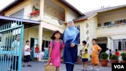 Seorang ibu menjemput anaknya pulang dari taman kanak-kanak di sebuah wilayah di Sarawak di mana bahasa ibu dipergunakan dalam program pengajaran, bukan bahasa Melayu.