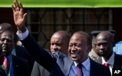 FILE - Kenya's President-Elect Uhuru Kenyatta gestures to supporters as he leaves the National Election Center where final election results were announced declaring he would be the country's next president, in Nairobi, March 9, 2013.