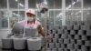 FILE - A worker packages spools of cotton yarn at a Huafu Fashion plant, as seen during a government-organized trip for foreign journalists, in Aksu in western China's Xinjiang Uyghur Autonomous Region, April 20, 2021.