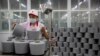 FILE - A worker packages spools of cotton yarn at a Huafu Fashion plant, as seen during a government organized trip for foreign journalists, in Aksu in western China's Xinjiang Uyghur Autonomous Region, April 20, 2021.