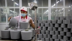 FILE - A worker packages spools of cotton yarn at a Huafu Fashion plant, as seen during a government organized trip for foreign journalists, in Aksu in western China's Xinjiang Uyghur Autonomous Region, April 20, 2021.
