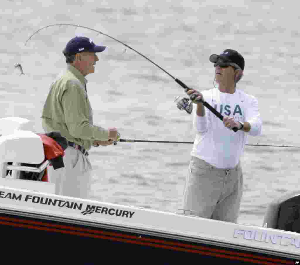 Then President George W. Bush casts over his father, former President George H. Bush, left, while fishing near Kennebunk, Maine, June 29, 2007. 