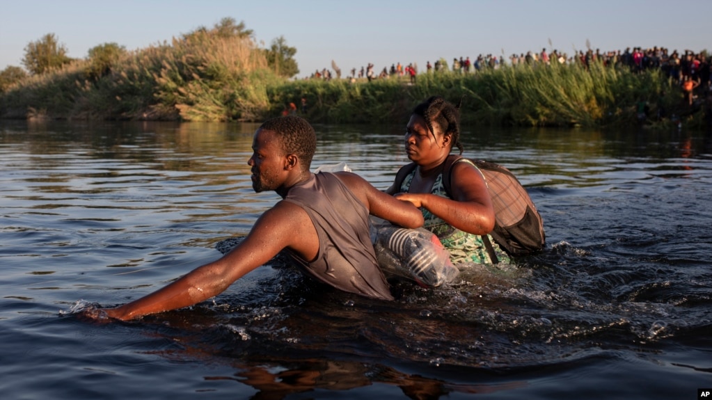 包括很多海地人在内的移民淌水越过格兰德河，返回美-墨边境墨西哥一侧的阿库尼亚城，以避免被美国遣返。(2021年9月20日)(photo:VOA)