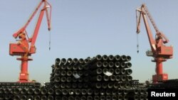 FILE - Cranes are seen above piles of steel pipes to be exported at a port in Lianyungang, Jiangsu province, China, Dec. 1, 2015. 