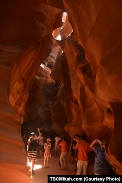Visitors to Upper Antelope Canyon east of Page, Arizona, marvel at the natural splendor of the sand-swept cavern.