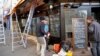 Men work on the shop front of the cafe "La bonne biere", one of the establishments targeted during the November Paris attacks, in Paris, Thursday, Dec. 3, 2015.