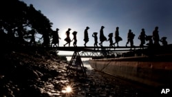 Unskilled workers unload pebbles form a tug boat in Rangoon, Burma, November 23, 2012. 