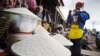 Une vendeuse emballe une portion de riz pour un client au marché d'Agbogboloshie à Accra, au Ghana, vendredi 6 juin 2008. 