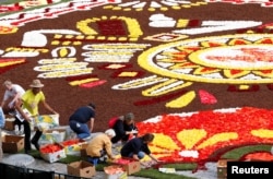 Gardeners adjust flowers on a 1,800-square-meter flower carpet at Brussels' Grand Place, Belgium, Aug. 16, 2018.