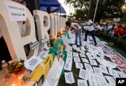 Friends and relatives light candles during a march paying homage to the victims of a mining dam collapse a week ago, in Brumadinho, Brazil, Feb. 1, 2019.