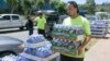 FILE - A worker at the Hawaiian water company carries bottle of water to customers hoping to stockpile water before a 2014 tropical storm.
