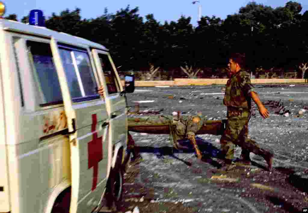 FILE - An injured service member is carried on a stretcher after a suicide truck bomb struck the U.S. Marine barracks in Beirut, Lebanon, Oct. 23, 1983.