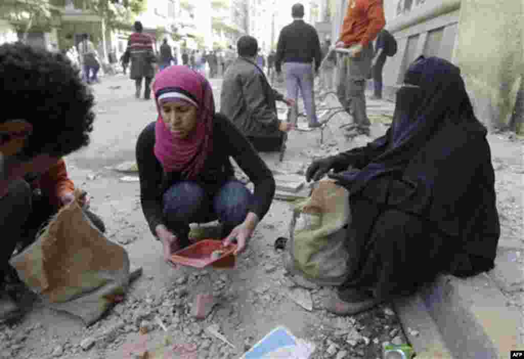Women collect stones in the main square of Cairo, Egypt, Thursday, Feb. 3, 2011. Egypt's prime minister apologized for an attack by government supporters on protesters in a surprising show of contrition Thursday, and the government offered more concession