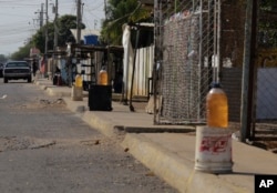 Bottles of black-market gasoline sit for sale on a sidewalk in Maracaibo, Venezuela, Jan. 30, 2019 photo.