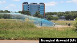 FILE: A Zimbabwean police water cannon disperses war veterans who had gathered to demonstrate against a faction within the ruling Zanu pf party reportedly led by the First Lady Grace Mugabe in Harare, Thursday, Feb. 18, 2016. (AP Photo/Tsvangirayi Mukwazhi)