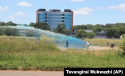 FILE: Police spray water on demonstrating war veterans.