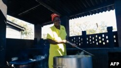 Une détenue inspecte ses pots alors qu'elle prépare un après-midi pour ses compagnons lors d'une visite guidée de la prison de Chikurubi par des membres d'un comité parlementaire de la santé, le 13 juin 2019.