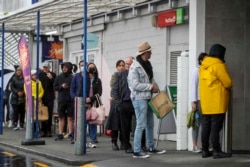 Para pelanggan antre saat akan berbelanja di sebuah supermarket di Auckland, Selandia Baru, 17 Agustus 2021.