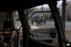 Soldiers patrol a street near the central square blocked by Kazakh troops and police in Almaty, Kazakhstan, Jan. 10, 2022.