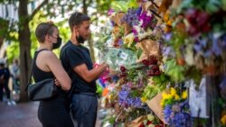 People read cards left with flowers in memory of Anglican Archbishop Emeritus Desmond Tutu at St. George's Cathedral, Dec. 31, 2021, in Cape Town, South Africa.