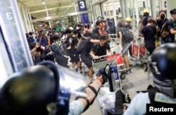 Policija koristi biber sprej protiv demonstranata na aerodromu u Hong Kongu, 14. avgusta 2019.