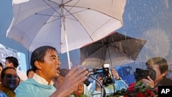 Thailand's Prime Minister Abhisit Vejjajiva speaks in the rain to supporters during final campaigning for Sunday's general election, Bangkok, July 1, 2011.