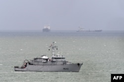 French navy minehunter ship Cassiopee, center, cruises off the cost of Le Havre harbor, Normandy, May 9, 2019, as the French government confirmed the day before that a new shipment of weapons will head for Saudi Arabia on the Saudi cargo ship Bahri Yanbu from Le Havre, despite claims that Riyadh is using the arms in the devastating war in Yemen.