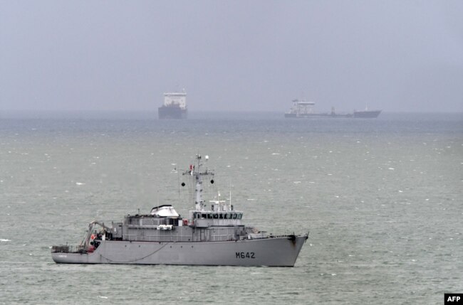 French navy minehunter ship Cassiopee, center, cruises off the cost of Le Havre harbor, Normandy, May 9, 2019, as the French government confirmed the day before that a new shipment of weapons will head for Saudi Arabia on the Saudi cargo ship Bahri Yanbu from Le Havre, despite claims that Riyadh is using the arms in the devastating war in Yemen.