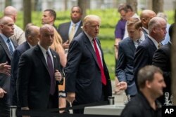 Republican presidential candidate Donald Trump, center, arrives to attend a ceremony at the National September 11 Memorial, in New York, Sept. 11, 2016, on the 15th anniversary of the Sept. 11 attacks.