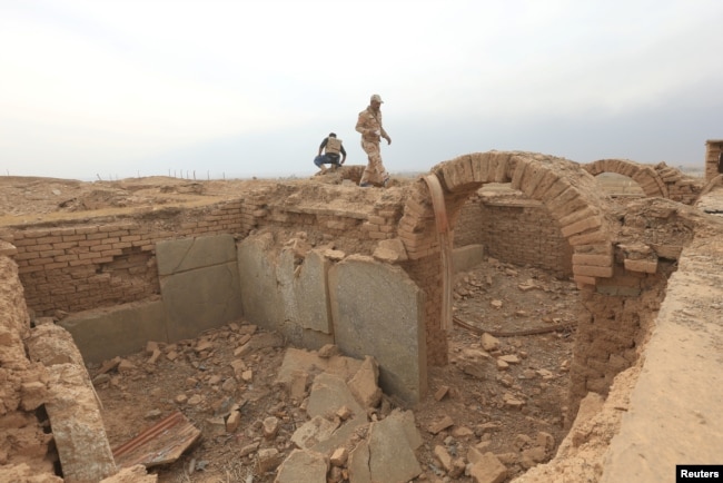 A member of the Iraqi army walks around the remains of wall panels and colossal statues of winged bulls, destroyed by Islamic State militants in the Assyrian city of Nimrud, south of Mosul, Iraq, Nov. 16, 2016.