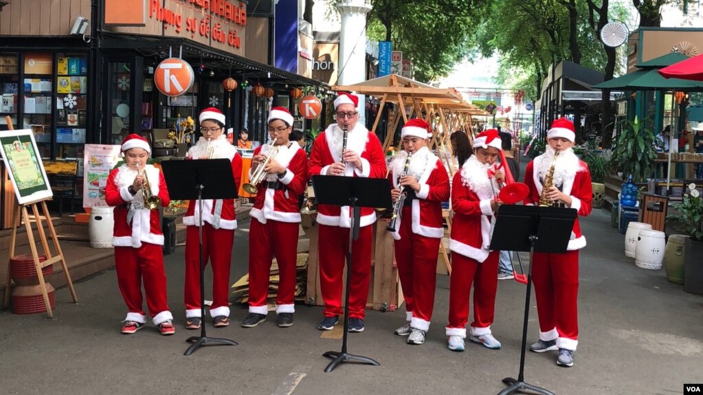 Ban nhạc Santa Claus trình diá»
n trên con ÄÆ°á»ng mang tên Tá»ng Giám mục Nguyá»
n VÄn Bình, bên cạnh Bưu Äiá»n TPHCM và o dá»p Giáng Sinh 2017.