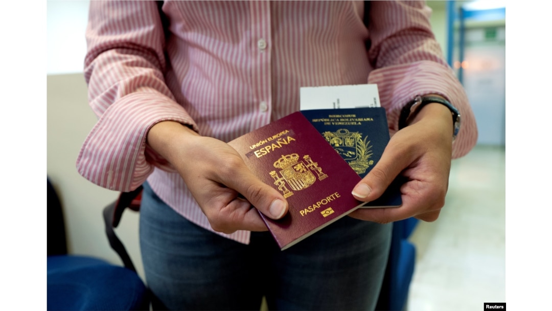 Mariana Elias, 27, shows her Venezuelan and Spanish passports at the Simon Bolivar International Airport, La Guaira, Venezuela, Jan. 14, 2019.