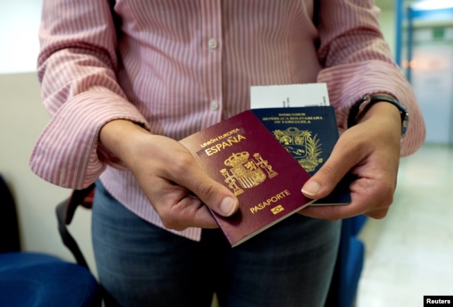 Mariana Elias, 27, shows her Venezuelan and Spanish passports at the Simon Bolivar International Airport, La Guaira, Venezuela, Jan. 14, 2019.