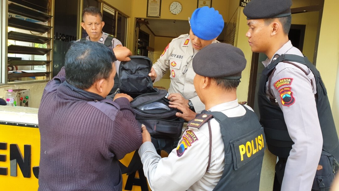 Sejumlah polisi menggeledah tas milik pengunjung yang akan memasuki kompleks Mapolresta Solo, Rabu, 13 November 2019. (Foto: VOA/Nurhadi)