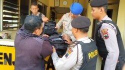 Sejumlah polisi menggeledah tas milik pengunjung yang akan memasuki kompleks Mapolresta Solo, Rabu, 13 November 2019. (Foto: VOA/Nurhadi)