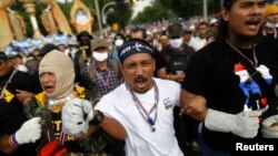 Anti-government protesters shout as they get ready to attack a police barricade near the Government house in Bangkok, Nov. 25, 2013. 