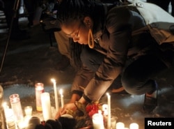 People place candles in a makeshift memorial at a vigil in honor of Bettie Jones, a mother of five, and college student Quintonio LeGrier, at Gwendolyn Brooks Academy in Chicago, Illinois, Dec. 29, 2015.